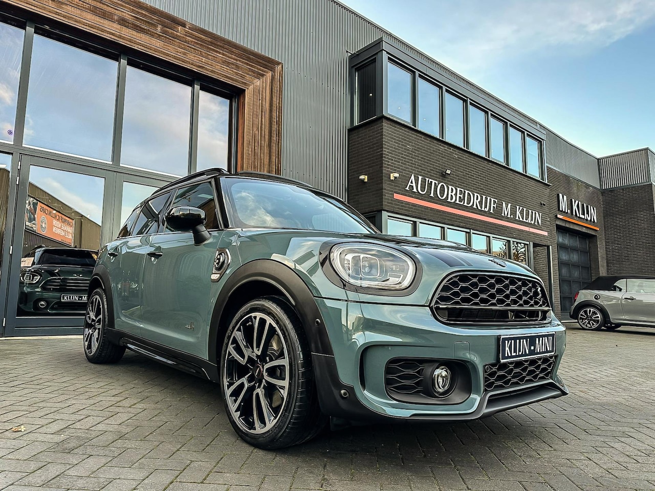 MINI Countryman - Mini 2.0 Cooper S E ALL4 John Cooper Works 220pk/Sage Green/bruin leer/camera/pano/btw - AutoWereld.nl