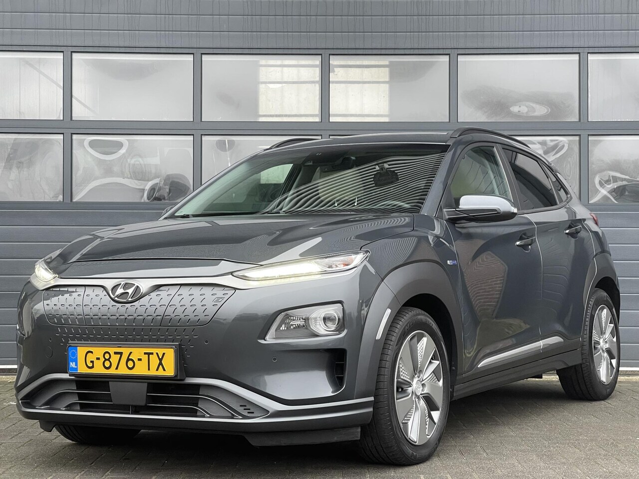 Hyundai Kona Electric - EV PREMIUM 64 KWH I TREKHAAK I SCHUIF/KANTELDAK I LEDEREN BEKLEDING I ACHTERUITRIJCAMERA - AutoWereld.nl