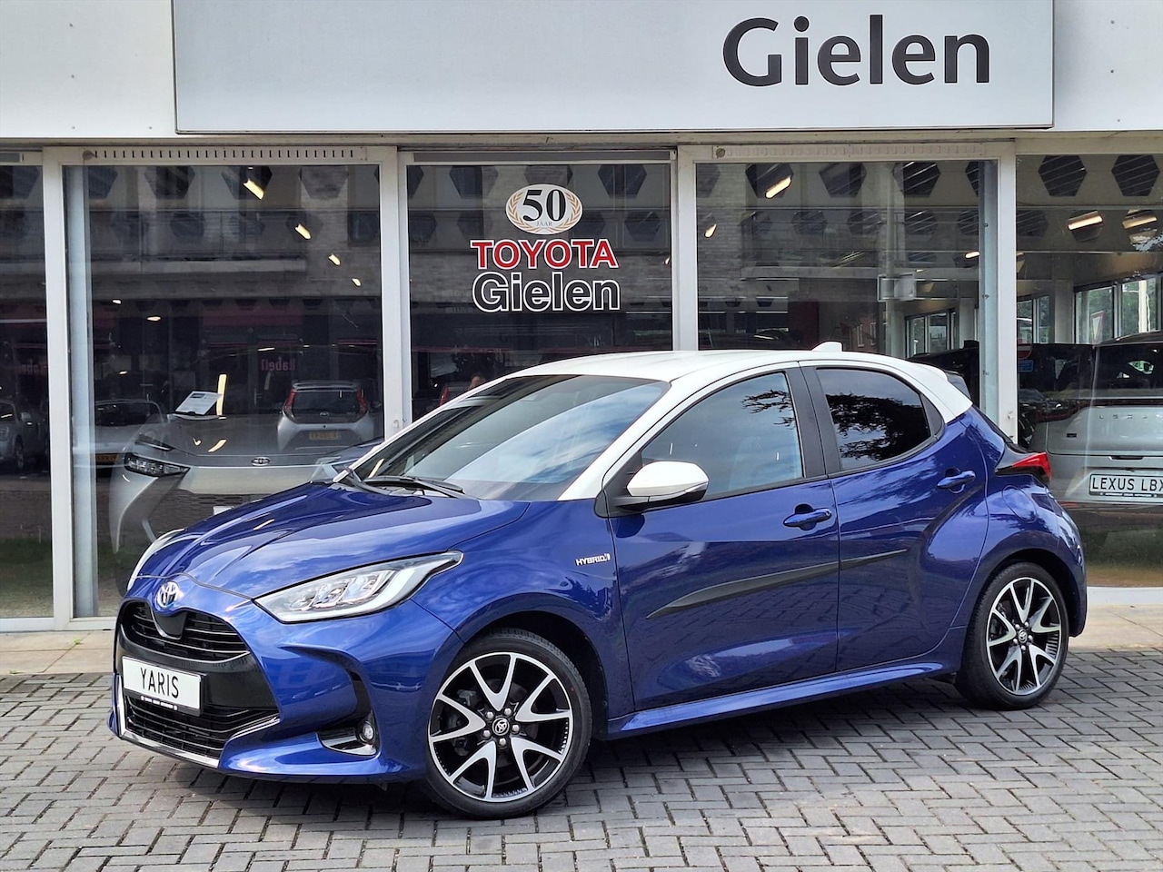 Toyota Yaris - 1.5 Hybrid Style Bi-Tone | 17 inch, Stoelverwarming, Half Leer, Keyless, Privcay Glass, Ap - AutoWereld.nl