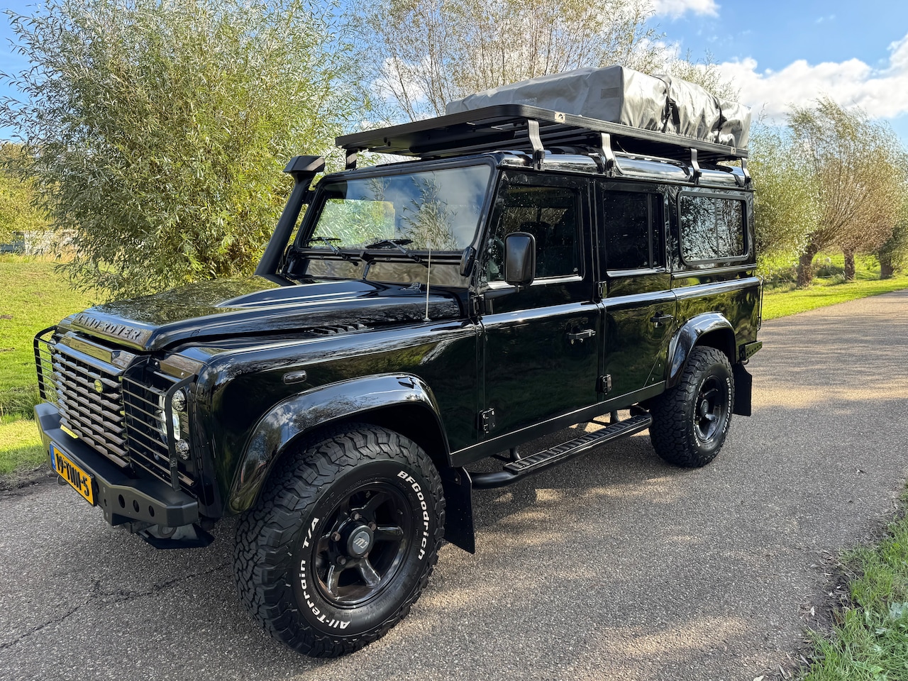 Land Rover Defender - 2.4 TD 110 SW E Prachtige zwarte Defender met snorkel, roofrack (flatdog) en complete Yuna daktent - AutoWereld.nl