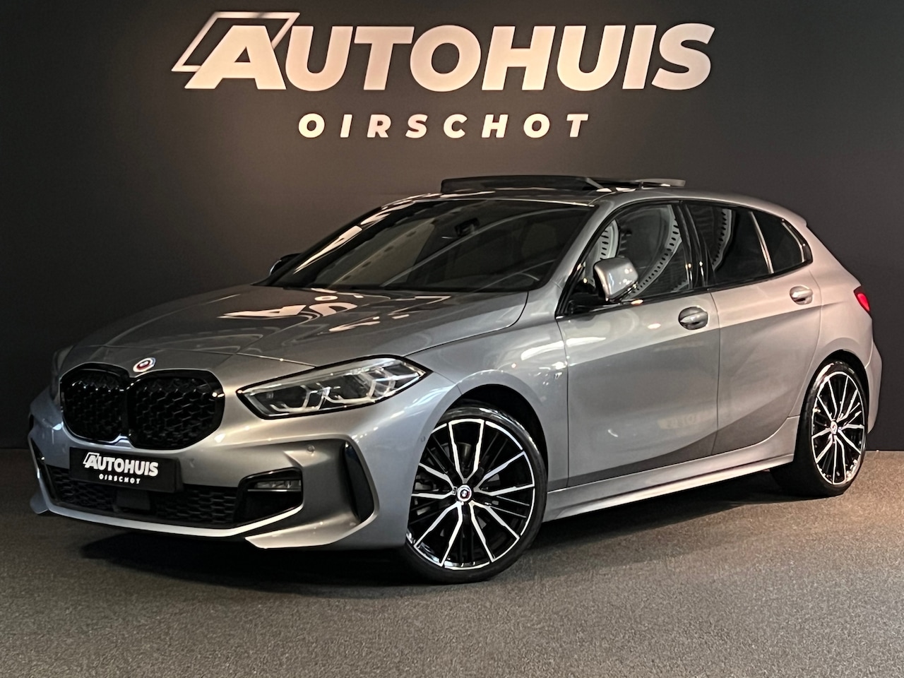 BMW 1-serie - 120i High Executive Edition M Pano/ M stoelen/ H&K/ 19"/ Camera/ Keyless/ Skyscraper Grau - AutoWereld.nl
