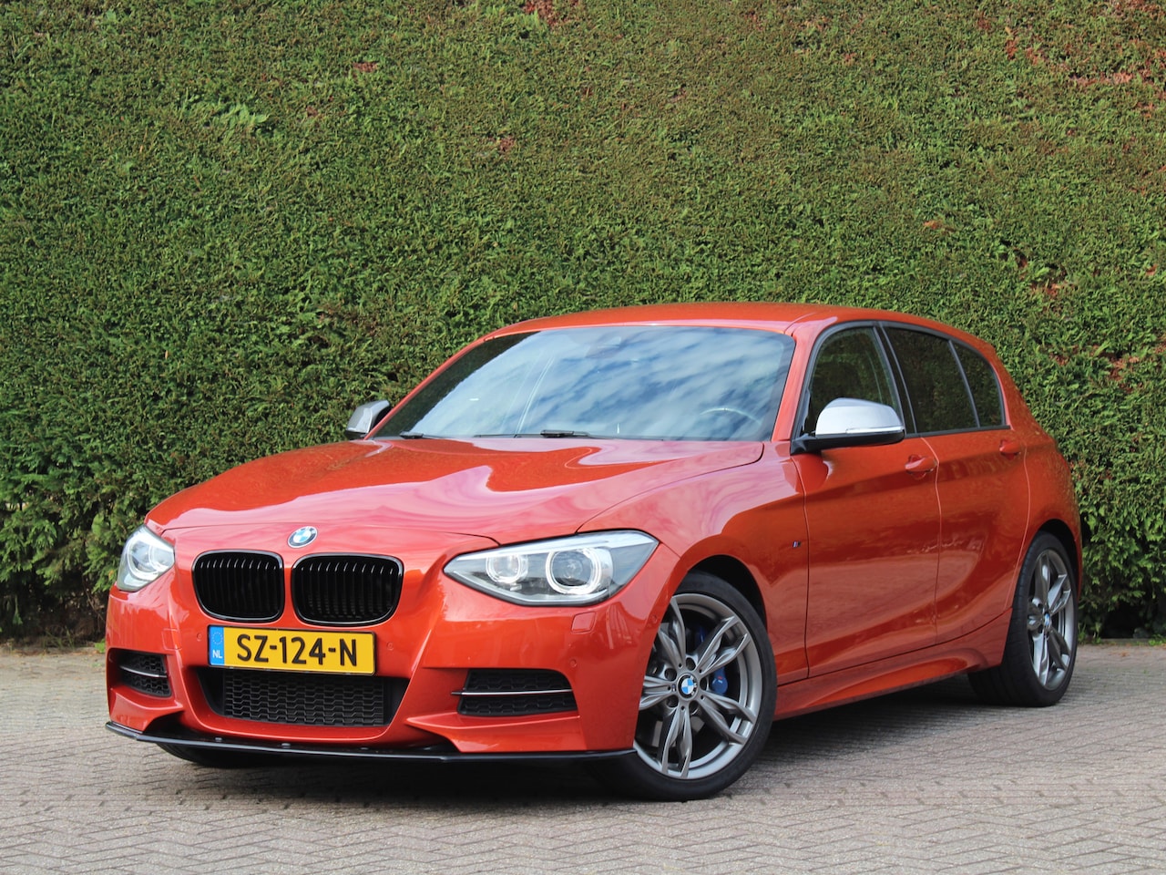 BMW 1-serie - M135i xDrive High Executive | M Performance uitlaat | Valencia orange - AutoWereld.nl